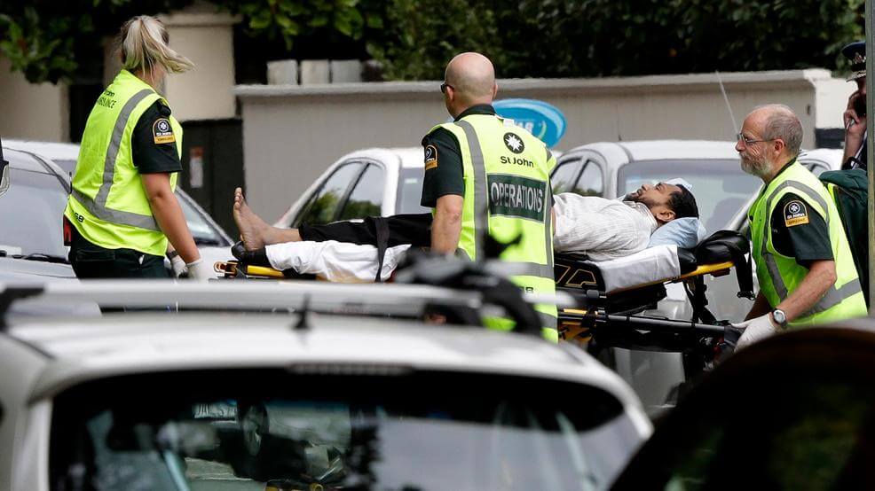 Ambulance staff taking away an injured man outside the Mosque